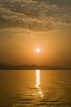 Samos, Northern Aegean, Greece. Vathy. Sunset over Samos seen from ferry between Samos and Athens