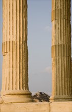 Athens, Attica, Greece. Part view of Acropolis and Parthenon columns framing distant view towards