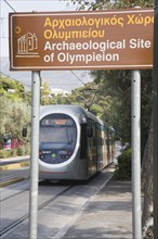 Athens, Attica, Greece. Modern tram adjacent to The Temple of Olympian Zeus with tourist heritage