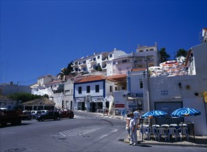 Carvoeiro, Algarve, Portugal. Typical street with white washed buildings tourists and traffic