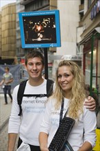 Budapest, Pest County, Hungary. Attractive young student couple promoting mobile internet access