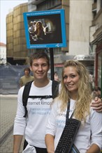 Budapest, Pest County, Hungary. Attractive young student couple promoting mobile internet access