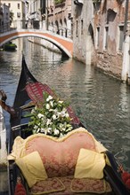 Venice, Veneto, Italy. Gondola prepared for wedding with flowers and red and gold brocade seating