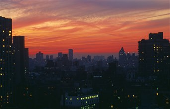 New York, New York State, USA. Upper East Side city skyline at dusk with red and purple sunset sky.