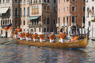 Venice, Veneto, Italy. Regatta Storico historical annual regatta. Team of rowers wearing orange and