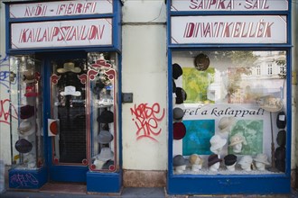 Budapest, Pest County, Hungary. Graffiti on hat shop facade around window display. Hungary