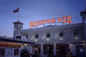 Brighton, Sussex, England. Brighton Pier sign illuminated over pier arcade entrance at night