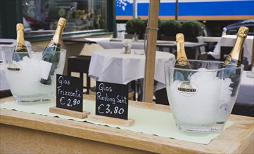 Vienna, Austria. The Naschmarkt Ice buckets with bottles of sparkling Riesling on side table in