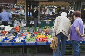 Vienna, Austria. The Naschmarkt. Customers selecting fresh fruit from display on stall that
