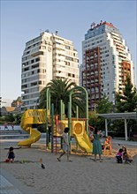 Santiago, Chile. Children playing in the sand while their mothers watch at a playground in Plaza