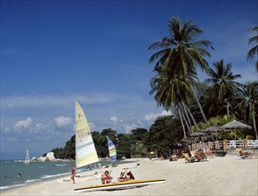 Batu Ferringhi, Penang, Malaysia. Beach scene with tourists sunbathing. Malaysia Malaysian