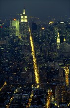 New York, New York State, USA. The Empire State Building illuminated at night with the city spread