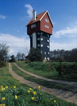 Thorpeness, Suffolk, England. Converted former water tower the House in the Clouds with daffodils