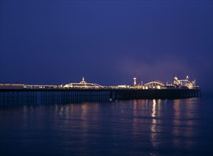 Brighton, East Sussex, England. Brighton Pier illuminated at night European Great Britain Nite