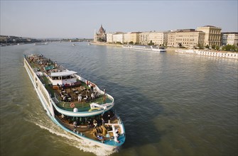 Budapest, Pest County, Hungary. Pleasure cruise boat on the River Danube approaching Szechenyi