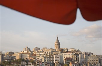 Istanbul, Turkey. Sultanahmet. View to Galata Tower from shade of red canopy alongside Galata
