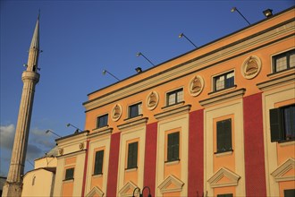 Albania, Tirane, Tirana, Pink and yellow government building facades beside minaret of Ethem Bey