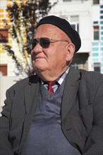Albania, Tirane, Tirana, Head and shoulders portrait of an elderly man wearing beret and sunglasses