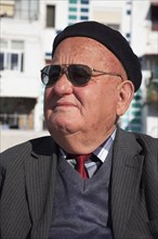 Albania, Tirane, Tirana, Head and shoulders portrait of an elderly man wearing sunglasses and a