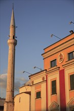 Albania, Tirane, Tirana, Pink and yellow government building facades beside minaret of Ethem Bey