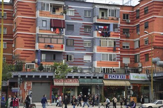Albania, Tirane, Tirana, Colourful apartment buildings with shops below.