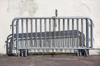 England, West Sussex, Bognor Regis, Galvanized crowd control barriers chained to a wall.