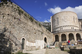 Albania, Kruja, Exterior walls of Kruja Castle and Skanderbeg Museum with craft and souvenir stalls