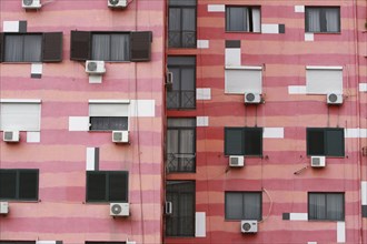 Albania, Tirane, Tirana, Part view of pink striped exterior facade of apartment building with air