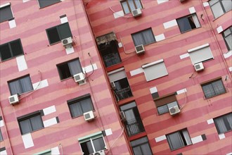 Albania, Tirane, Tirana, Angled part view of pink striped exterior facade of apartment building