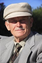 Albania, Tirane, Tirana, Head and shoulders  full face portrait of an elderly man wearing a hat.