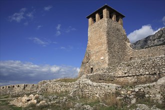Albania, Kruja, Stone watch tower of Kruja Castle and part ruined walls.