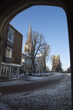 England, West Sussex, Chichester, Cathedral in snow seen through the arch of the market Cross.