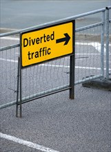Transport, Road, Signs, Yellow Diverted Traffic diversion sign on barrier across empty urban road