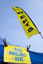 England, West Sussex, Bognor Regis, Yellow flag and sign on a tent that read Sweets and Rock
