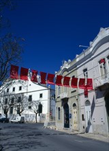 Portugal, Algarve, Faro, Typical streetscene with red banners stretched across the street.