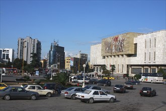 Albania, Tirane, Tirana, Traffic in Skanderbeg Square passing exterior facade of the National
