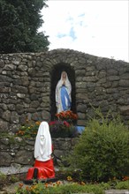 Ireland, General, Shrine in stone wall archway holding statue with flowers in front and statue of