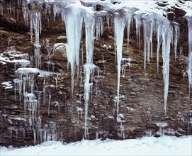 Climate, Winter, Ice, Long icicles hanging from rock face.
