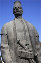 Albania, Tirane, Tirana, Three-quarter view of statue of standing male figure in traditional dress