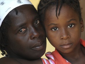 Haiti, La Gonave, Head and shoulders portrait of a mother and daughter.