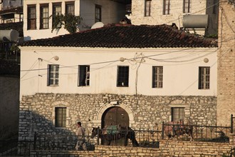 Albania, Berat, Traditional Ottoman buildings with person standing at upstairs window looking down