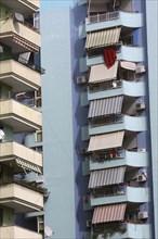 Albania, Tirane, Tirana, Detail of balconies and striped awnings on exterior facade of blue painted