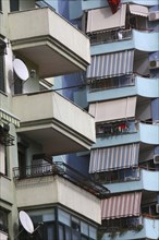 Albania, Tirane, Tirana, Detail of balconies  striped awnings and satellite dishes on blue painted
