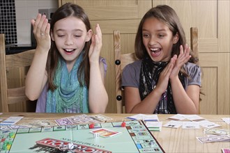 Children, Playing, Indoor, Two young girls playing game of Monopoly.