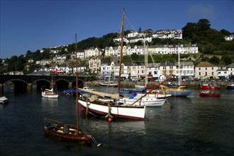 England, Cornwall, Looe, View over moored boats and bridge with waterfront architecture beyond