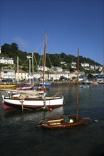 England, Cornwall, Looe, View over moored boats with waterfront architecture beyond