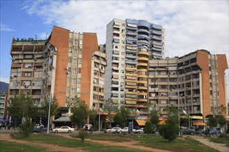 Albania, Tirane, Tirana, Apartment blocks with shops below  overlooking road and area of grass and