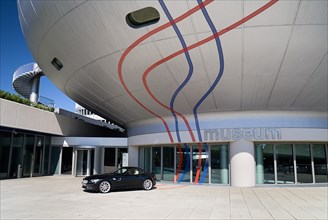 BMW Headquarters. The BMW Museum part view of orb shaped structure and entrance with car parked