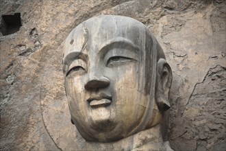 Carved Buddha statue in the Fengxian Temple Tang Dynasty Longmen Grottoes and Cave. Photo: Mel