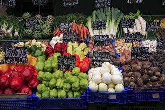 Vegetable stall in the Naschmarkt with display of produce including red and green peppers leeks and